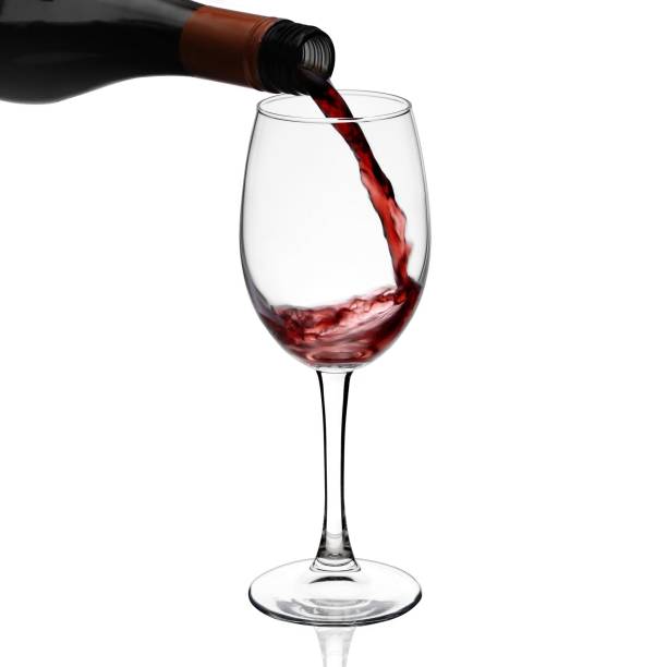 istock Red wine poured in a glass isolated on white 1253456108