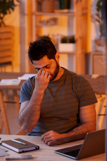 istock Exhausted Man Working Late at Home 1253456164
