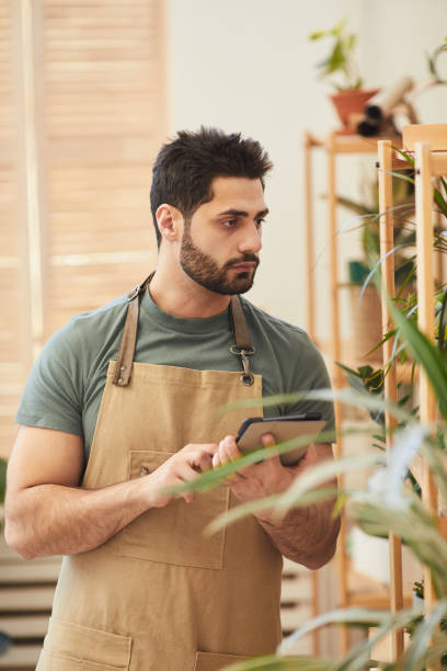 istock Male Worker Examining Houseplants 1253456312
