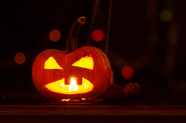 istock Halloween Jack O' lantern carved pumpkin on wooden background 1253456421