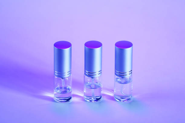 istock Three mini spray bottles in a row on a purple background 1253456640