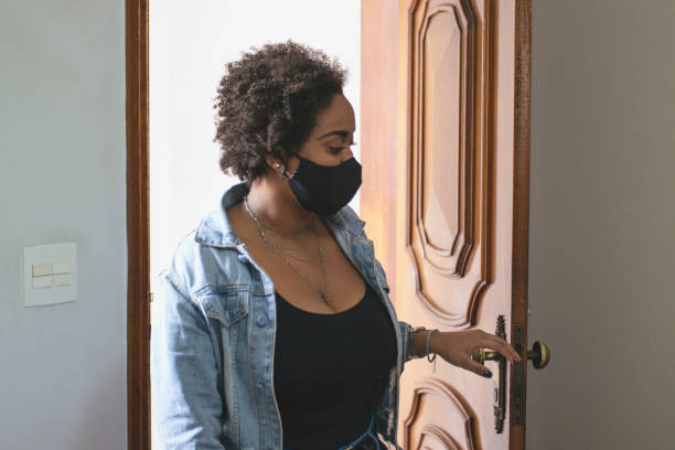 istock Woman entering at home wearing protective face mask. 1253456982
