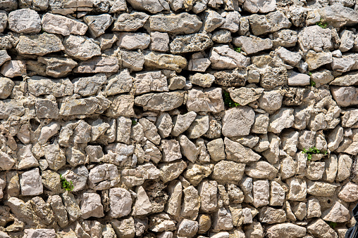 Old heaped stone wall full frame texture background.
