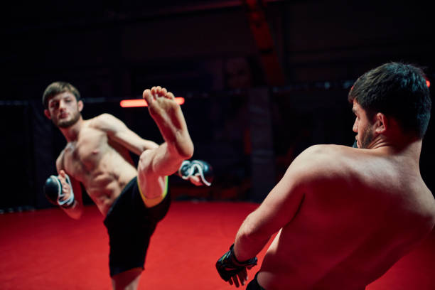 istock MMA fighters throw punches in octagon. High kick 1253460245