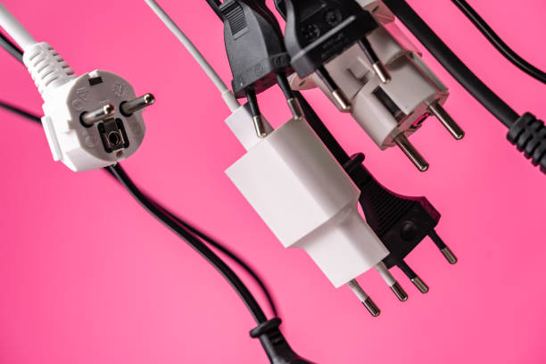 istock Crowded  white extension cord with many plugs on pink background 1253460275