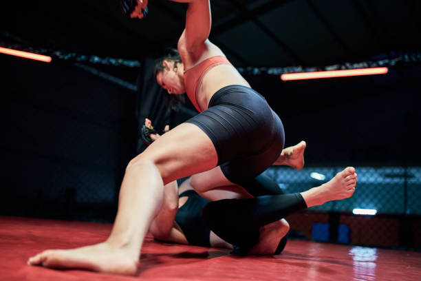 istock Female MMA fighters throw punches in octagon 1253460405