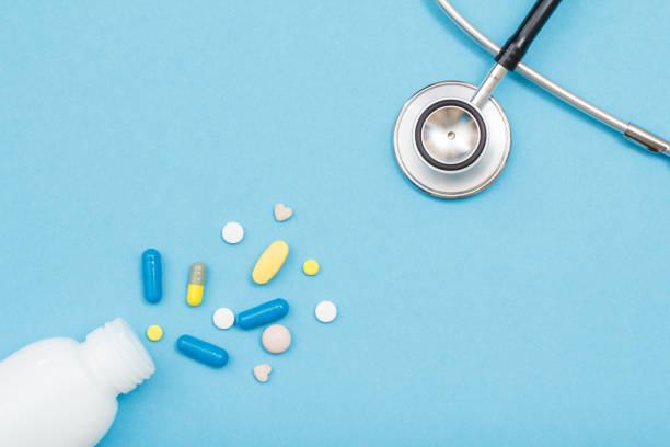 istock White bottle with different pills and phonendoscope on blue background 1253460729