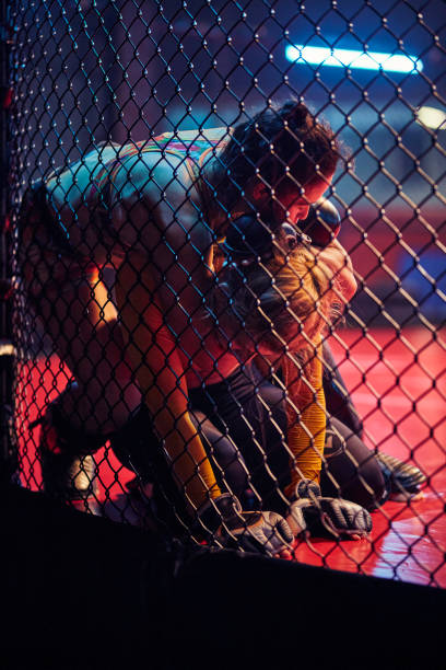 istock Female MMA fighters training in octagon. Choking rival 1253461642