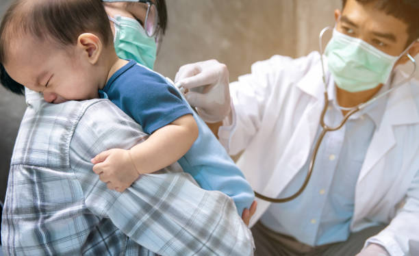 An Asian mother takes her son to the doctor. To check the body and diagnose the disease. stock photo