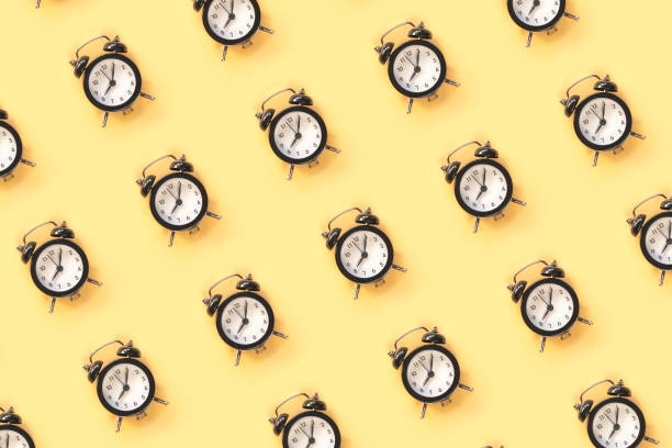 istock Pattern made of alarm clock on yellow background, top view 1253463538