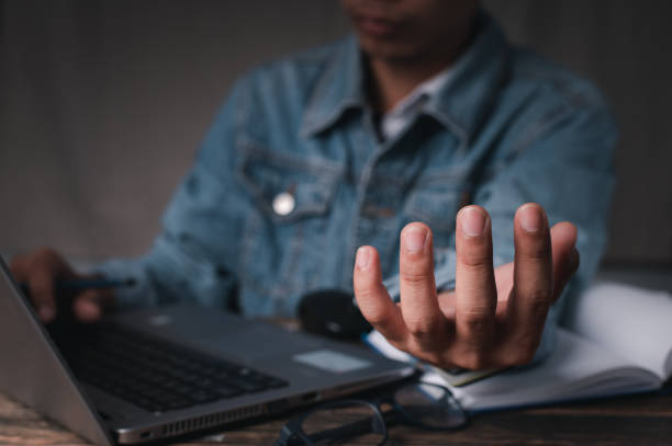 istock A man working on a laptop and held his other hand as though he were carrying something. concept working at home , concept working  in office. 1253463802
