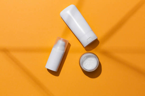 istock White blank cosmetic products bottles on orange background with free space for text, as advertisement. 1253465106