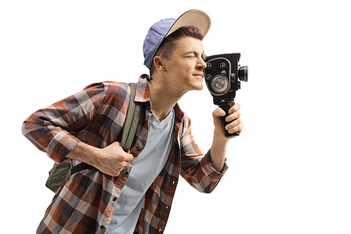 Male student with a backpack recording with a vintage 8mm camera isolated on white background