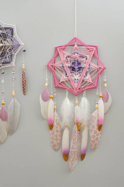 istock Yarn mandala with feathers and amethyst beads on grey background 1253466834