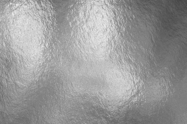 istock Silver foil texture background with highlights and uneven surface 1253467086