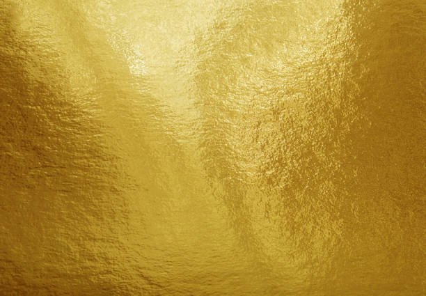 istock Gold foil texture background with highlights and uneven surface 1253467145