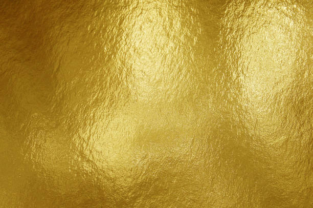 istock Gold foil texture background with highlights and uneven surface 1253467172