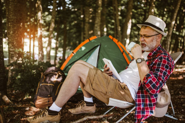 istock Man camping in nature taking rest drinking fresh coffee and writing in a notebook. 1253467187