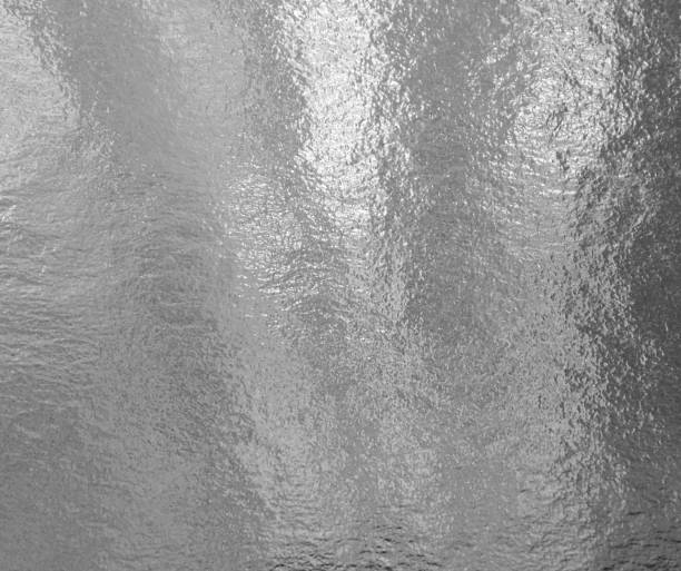 istock Silver shiny foil with highlights and uneven texture 1253467257
