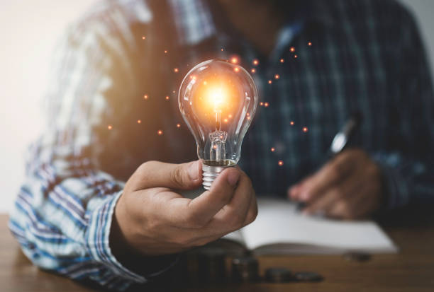 istock Businessman hand holding lightbulb with orange glowing and connection line. Creative thinking idea concept. 1253468621