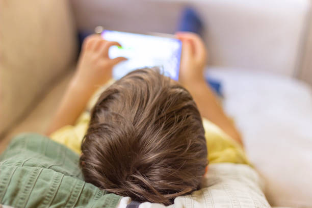 istock Little cute boy playing games on a tablet and watching cartoons. 1253471150