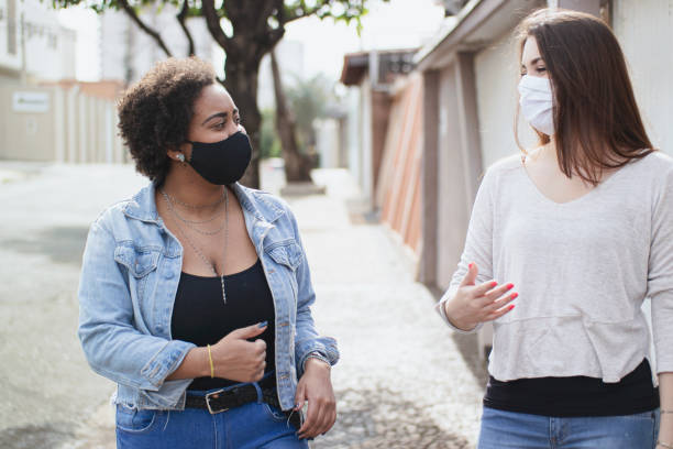 istock Women walking at street wearing protective face mask. 1253471590