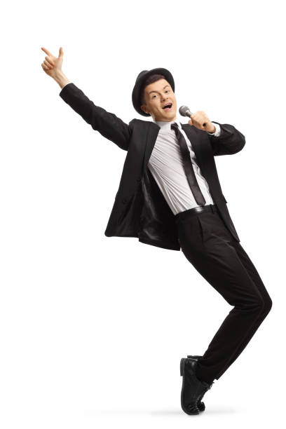 Young showman in a suit dancing and singing on a microphone