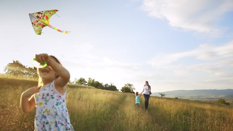 Little cheerful girl flying a kite