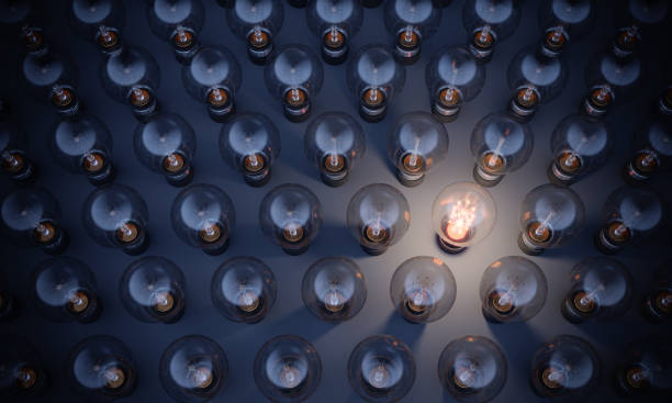 Glowing Light Bulb Standing Out From the Crowd Glowing Light Bulb between the others. Can be used leadership, innovation and individuality concepts.  (3d render) innovation individuality standing out from the crowd contrasts stock pictures, royalty-free photos & images