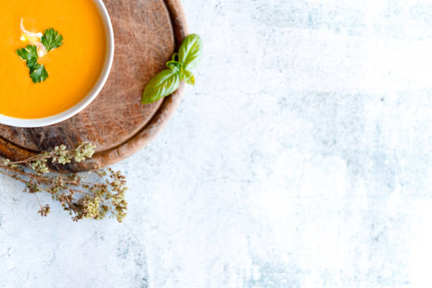 istock Delicious pumpkin soup in bowl on marble table, flat lay