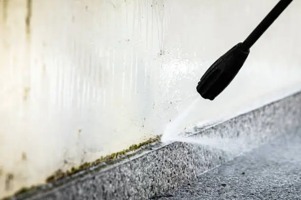 cleaning of a concrete wall with a high pressure cleaner, close up