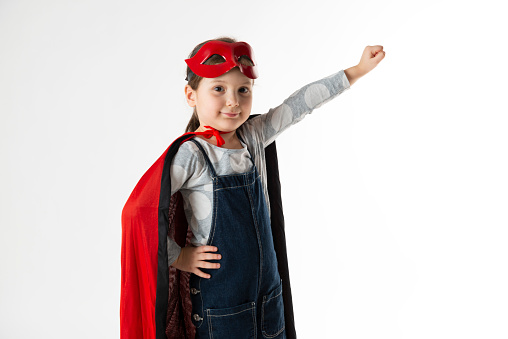 Little four years old girl with a handmade superhero disguise, white background.