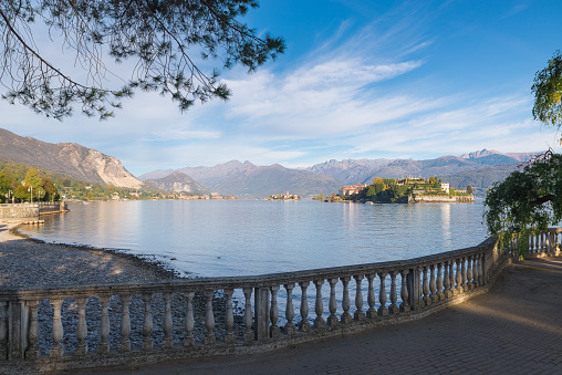 Panorama from the lakefront of the town of Stresa towards the Isola dei Pescatori (fishermen's island) and Isola Bella (beautiful island), in the background the Alps. Stresa is a famous town that overlooks the shores of lake Maggiore, on the Borromean Gulf, (golfo Borromeo) province of Verbano Cusio Ossola, piedmont, northern Italy. This is probably the most famous area and tourist destination of lake Maggiore, also known for its luxurious hotels; for the cable car that leads to the mountain called Mottarone (1500 m), a splendid viewpoint over the lake and the Alps, and for an important botanical garden