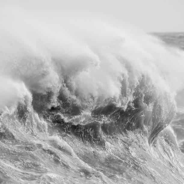 istock Amzing image of individual wave breaking and cresting during violent windy storm in black and white with superb detail 1253488419