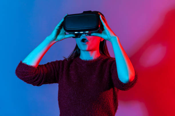 istock Surprised girl with virtual reality glasses playing game simulator, experiencing shock amazed emotions in cyberspace 1253489961