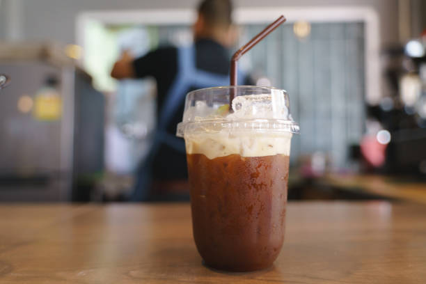 Plastic cup of iced cold brew coffee with slice of kiwi fruit