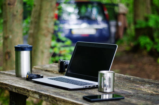 istock Computer Coffee Mug and Telephone on black wood table. 1253490168