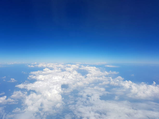 istock View on the blue sky with clouds from airplane window. 1253490819