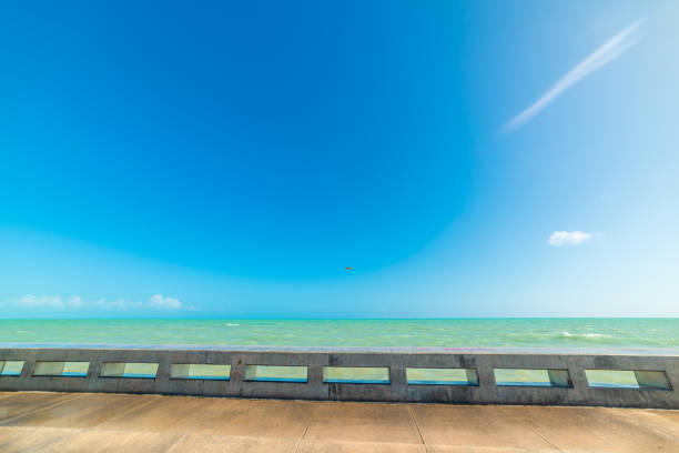 Beautiful Key West shoreline with a pier and waves splashing over the seawall.