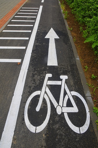 Road section with road markings regulating the movement of cyclists. Bicycle signs on the road. Bicycle road with arrow. Bicycle and modern ecological public movement.