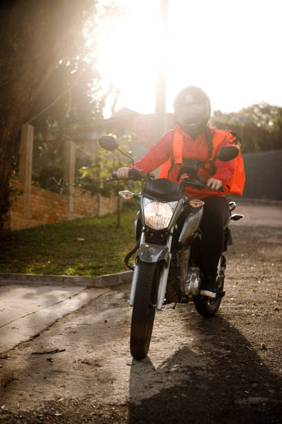 istock Delivery biker arriving at destination - motogirl 1253498868