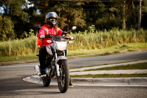 istock Delivery biker arriving at destination - motogirl 1253498874