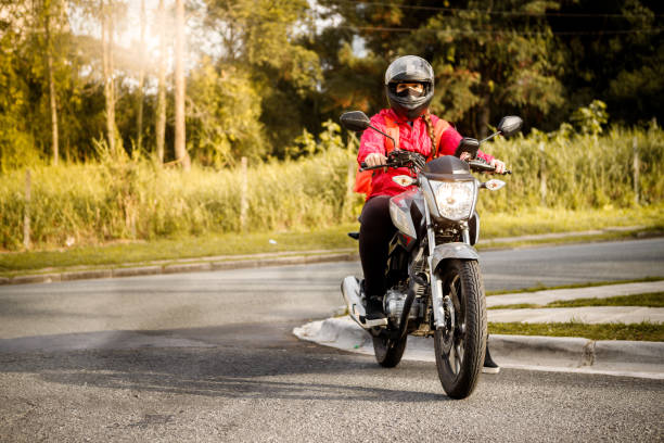 istock Delivery biker arriving at destination - motogirl 1253498877