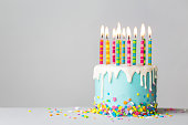 点滴アイシングとカラフルなキャンドルと誕生日ケーキ