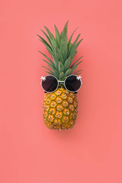frutta all'ananas con occhiali da sole su sfondo pastello rosa - 5504 foto e immagini stock