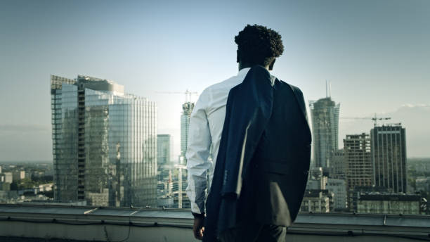 istock African businessman relaxing on a rooftop. Enjoying sunset after work 1253505545