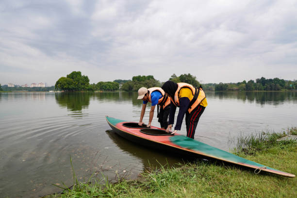 irmãos felizes com família caiaque lago ao ar livre - summer camp child teenager kayak - fotografias e filmes do acervo