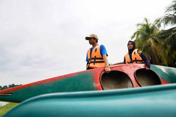 szczęśliwe rodzeństwo z rodziną kajak odkryty jezioro - summer camp child teenager kayak zdjęcia i obrazy z banku zdjęć