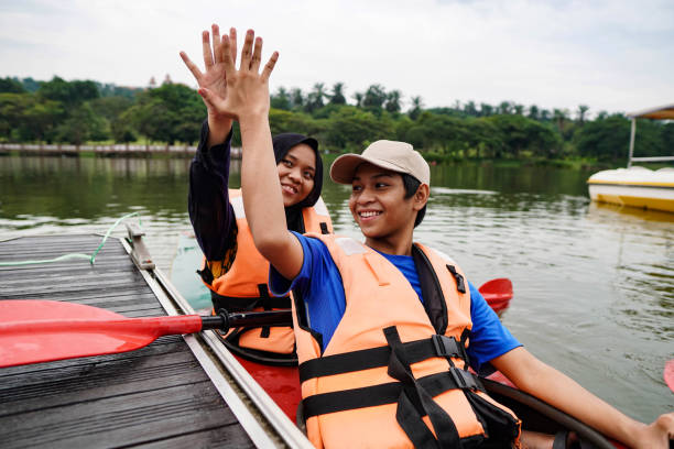 szczęśliwe rodzeństwo z rodziną kajak odkryty jezioro - summer camp child teenager kayak zdjęcia i obrazy z banku zdjęć