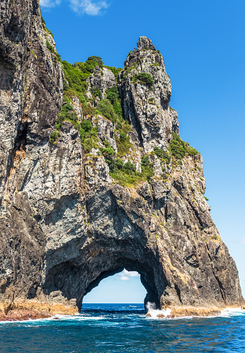 The famous 'Hole in the Rock', part of Piercy Island, a small island located on the outskirts of the Bay of Islands in New Zealand's Northland.